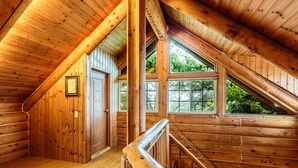 Ein Holzinnenraum mit schrägverdeckter Decke, Holzwänden und einer Treppe.