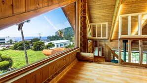 Ein Holzinnenraum mit einem großen Fenster mit Blick auf eine üppige Landschaft.