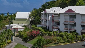 A resort with multiple-story buildings, balconies, and lush greenery. - Résidence Tropicale (Le Moule)