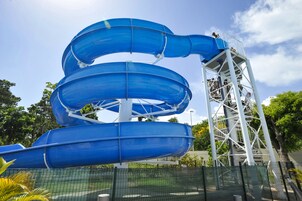 Estructura de tobogán acuático azul de varios niveles con una torre de soporte metálica.