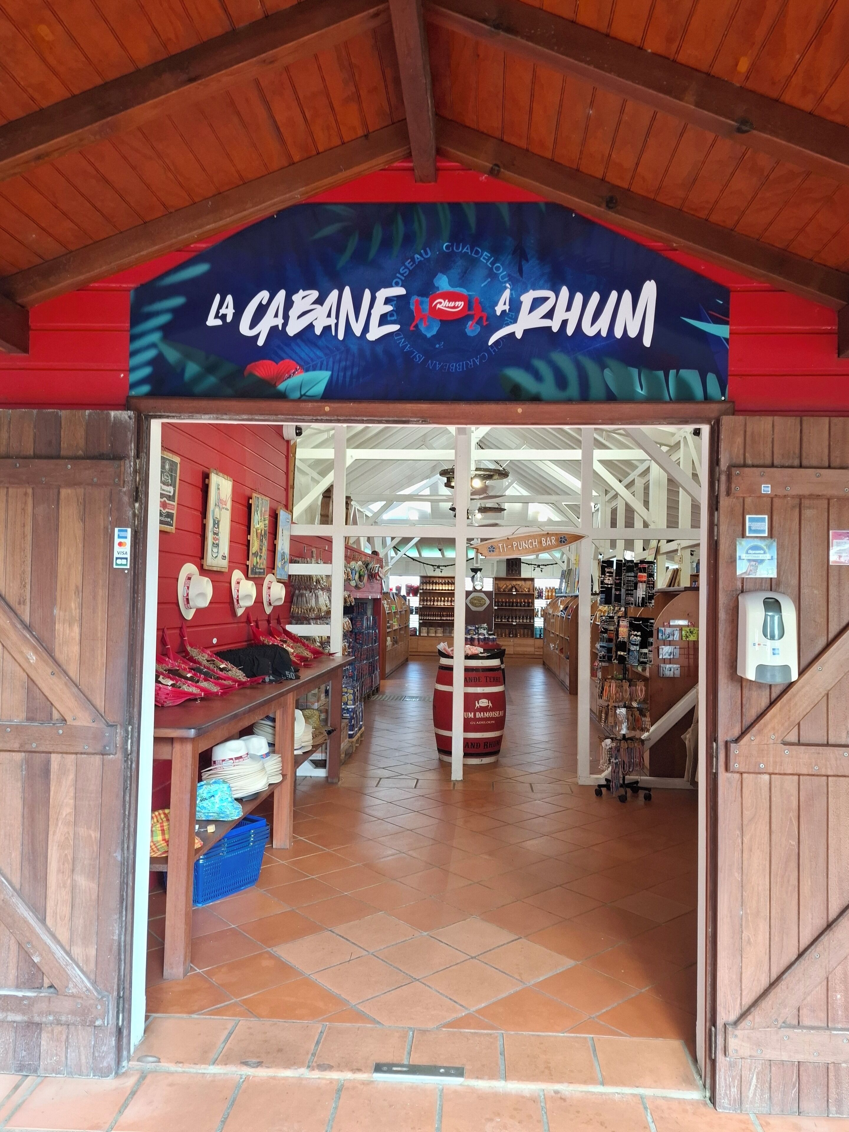 Indgangen til La Cabane Aquarium, med en trækonstruktion, flisegulv og diverse udstillingsgenstande indeni.