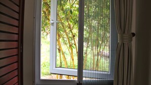 Janela com vista para árvores de bambu.