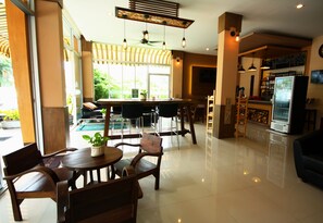 A modern interior with a dining area, bar, and seating space. - Breezotel (Patong)