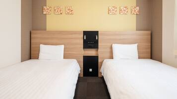 Hotelkamer met twee bedden, een houten hoofdeinde, een wandklok en een klein plankje met een fles en een afstandsbediening.