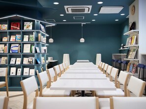 Una biblioteca moderna con estanterías, mesas y sillas dispuestas para la lectura.
