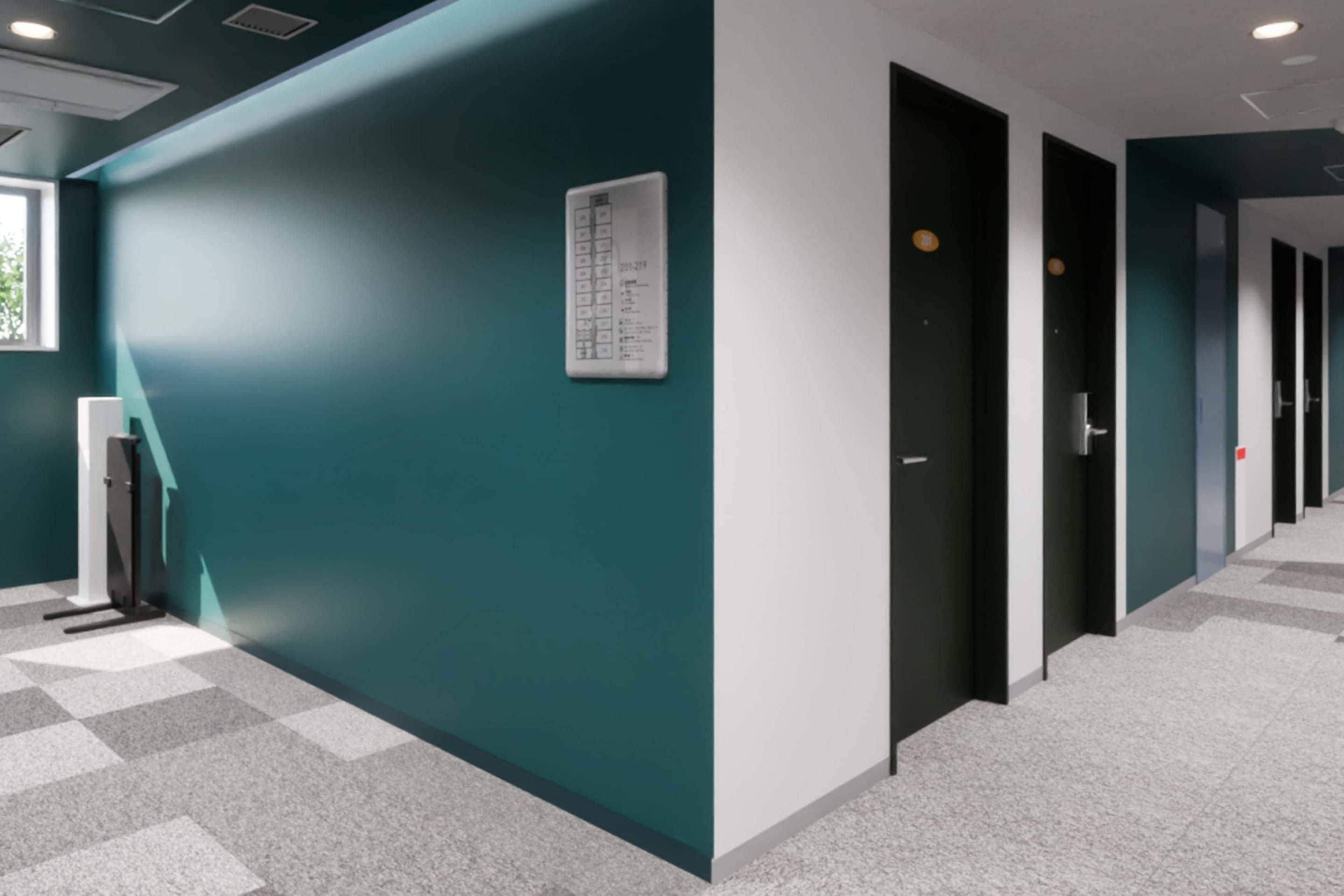 A hallway with teal walls, a whiteboard, and a checkered floor.