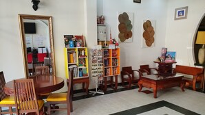 Una habitación acogedora con una mesa de comedor, sillas, una estantería y un espejo decorativo.