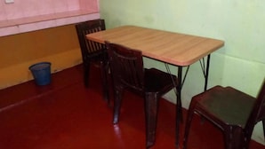 A small dining area with a wooden table and four chairs. - Pradeepa Guest House (Polonnaruwa)