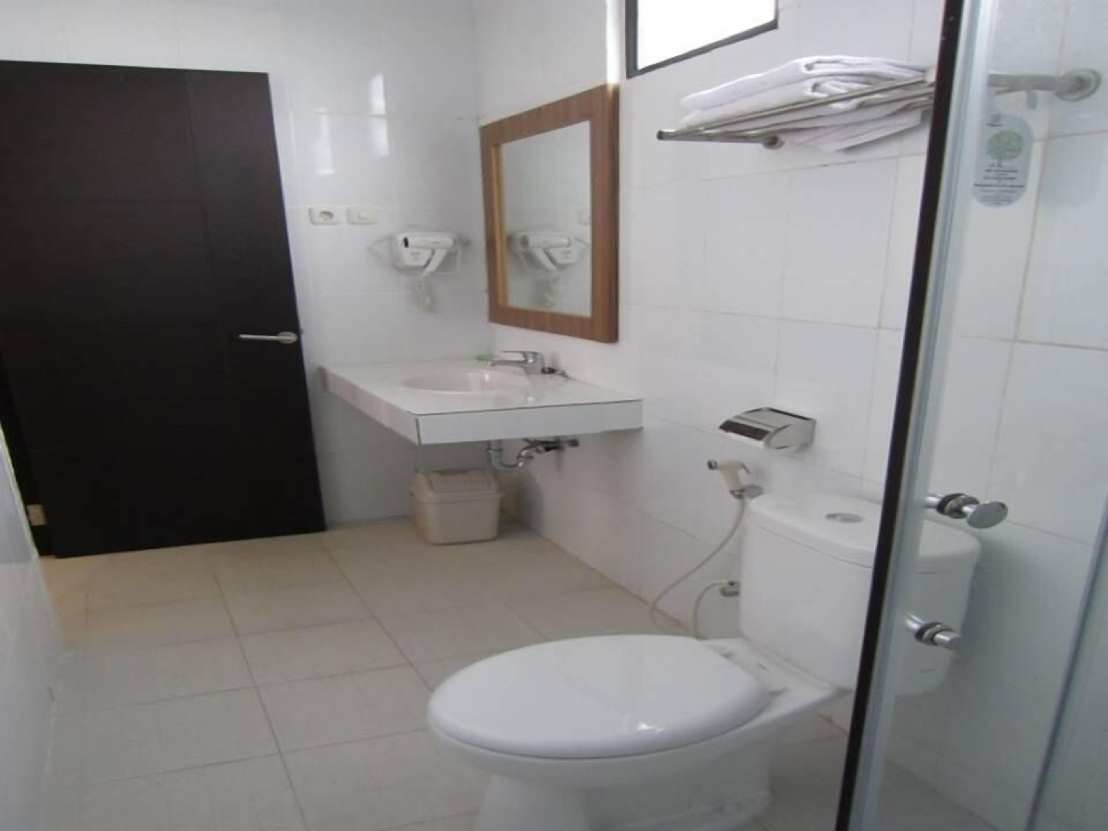 Un baño pequeño y limpio con inodoro blanco, lavamanos y espejo.