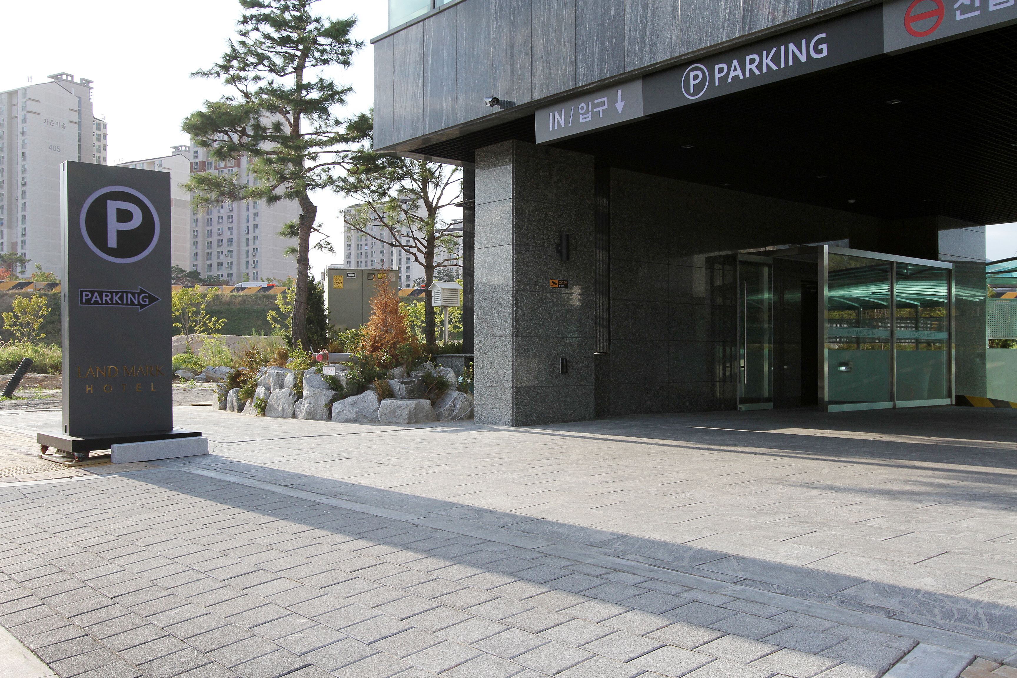 A modern building with a parking sign and a hotel sign.