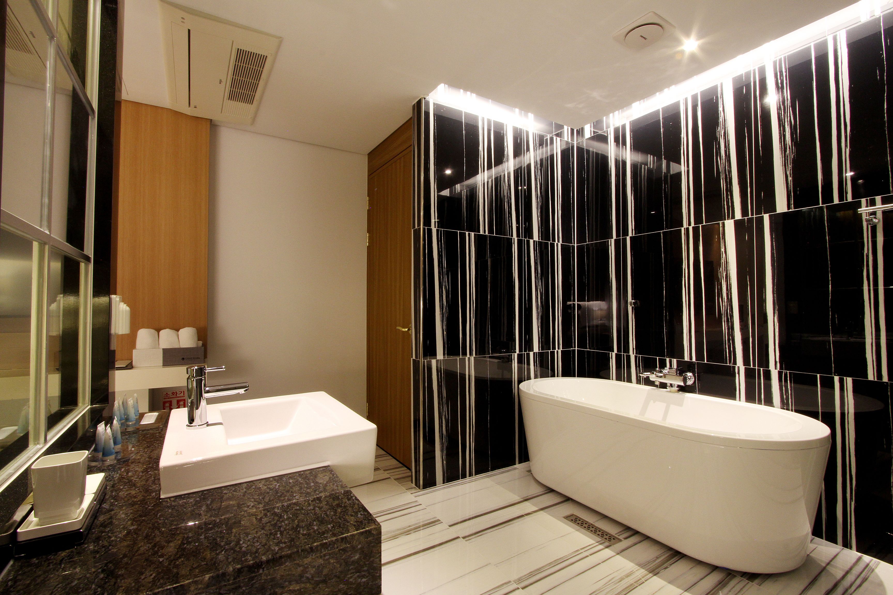 Un baño moderno con una bañera independiente, un tocador con lavabo y un espejo.