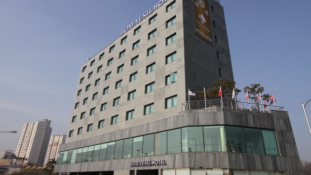 A modern hotel building with a prominent sign reading "Homaesil Hotel".