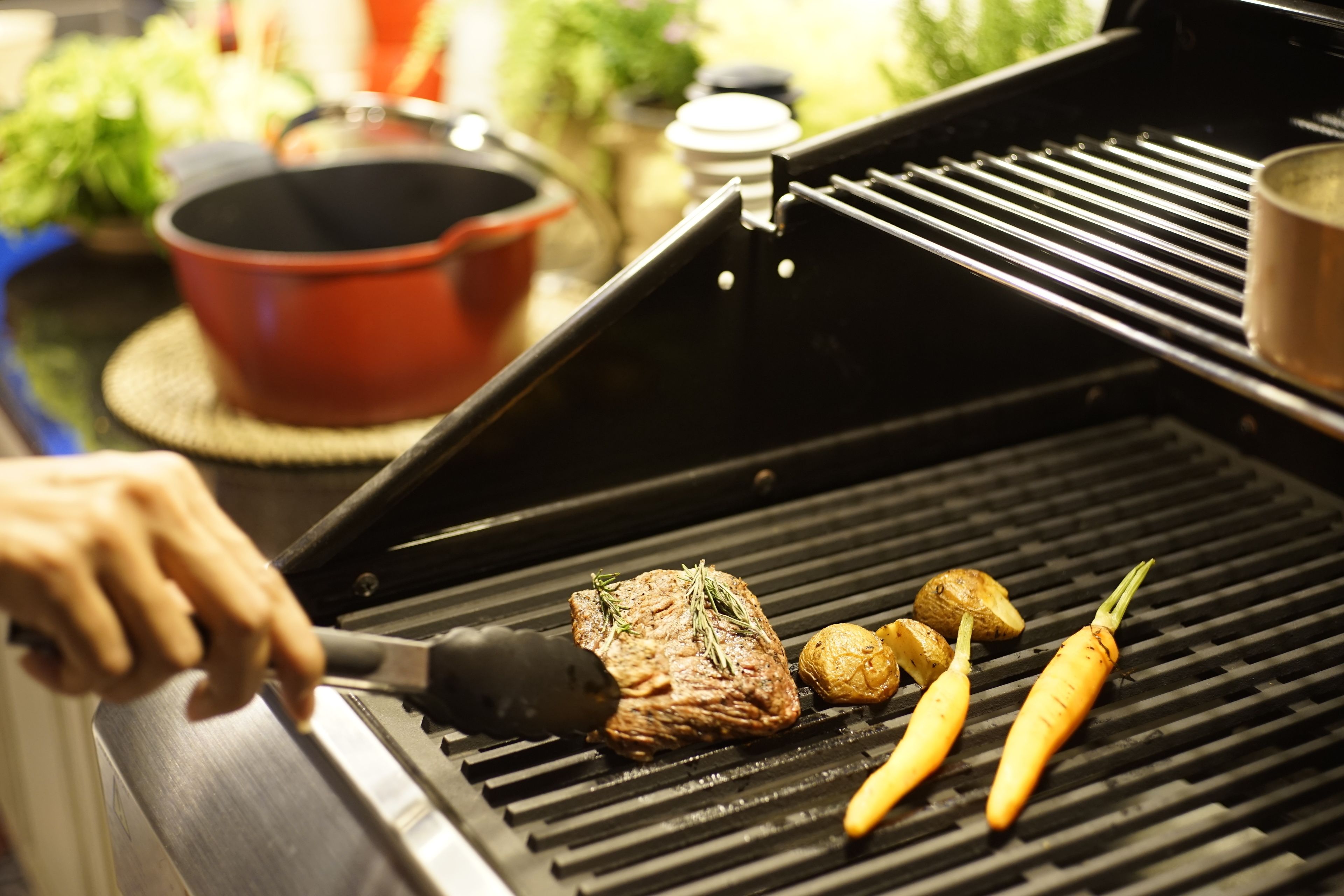A grill with meat and vegetables being cooked.