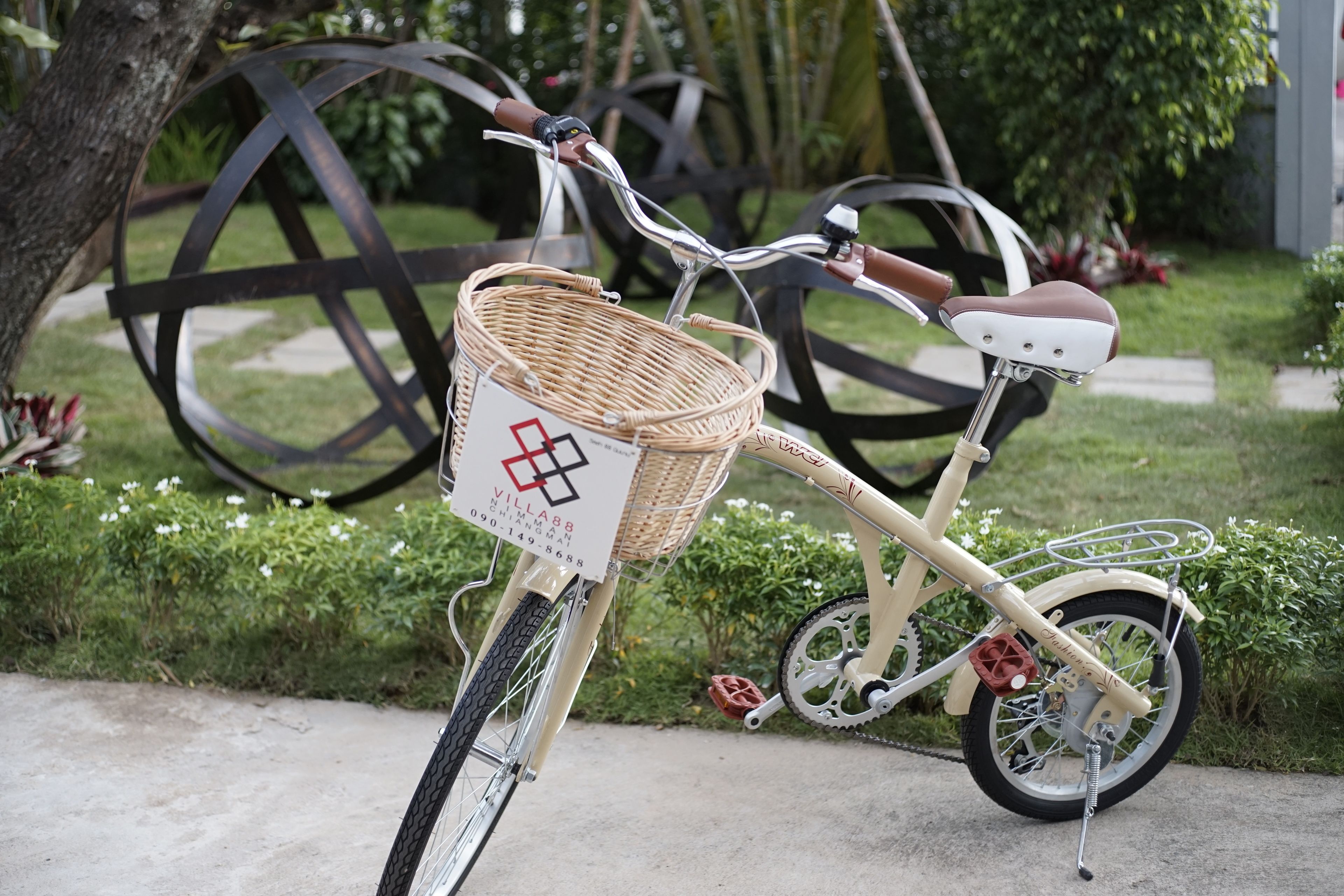 Una bicicleta antigua con una canasta de mimbre y un asiento acolchado.