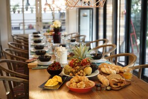 A breakfast table with fruits, pastries, and beverages. - Private Pool Villa 88 Nimman Chiangmai (Chiang Mai)