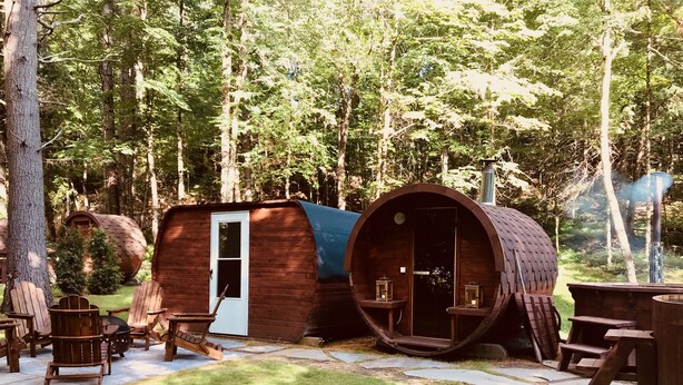 Una cabaña rústica con una puerta de madera y una estructura en forma de barril.