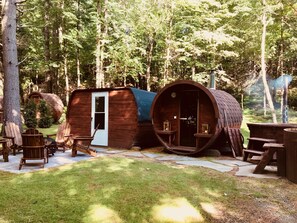 Une cabane rustique avec une porte en bois et une structure en forme de tonneau.