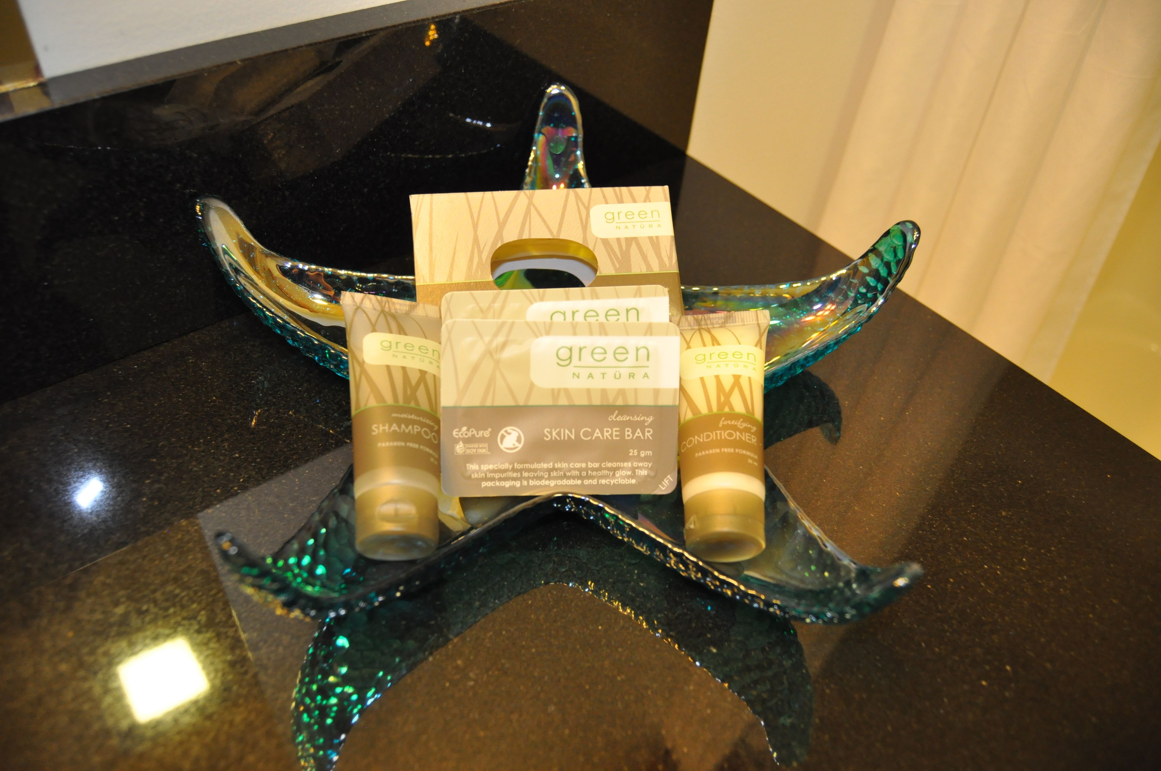 A display of green Natura skincare products on a star-shaped stand.