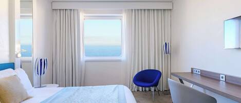 Une chambre d’hôtel avec un lit, un bureau, une chaise, une grande fenêtre avec des rideaux et une vue sur la mer.
