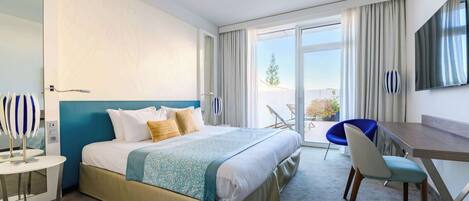 Ein Hotelzimmer mit Bett, Schreibtisch, Stuhl und großem Fenster.