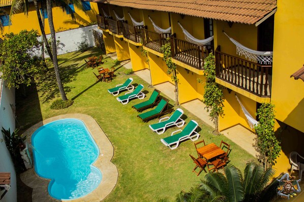 Una piscina al aire libre, sillones reclinables de piscina
