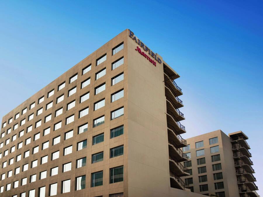 Un hotel alto y moderno con fachada plana y muchas ventanas.