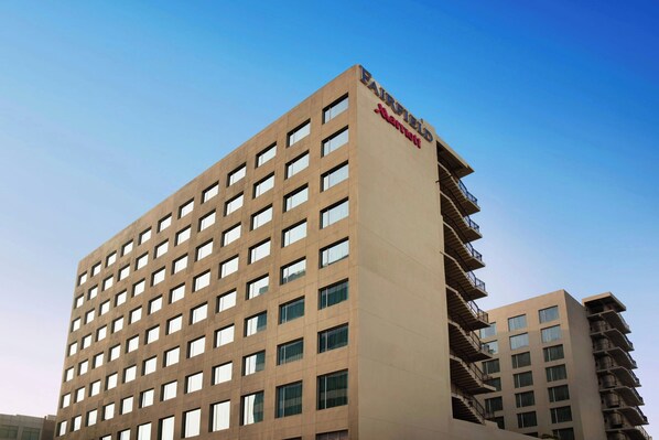 Un hotel alto y moderno con fachada plana y muchas ventanas.