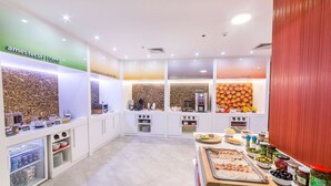 Una cocina moderna con barra americana, diferentes alimentos y una estación de café.