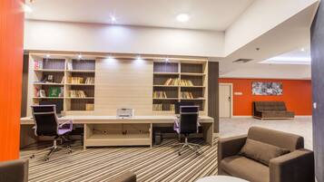 A modern library with two desks, chairs, and bookshelves.