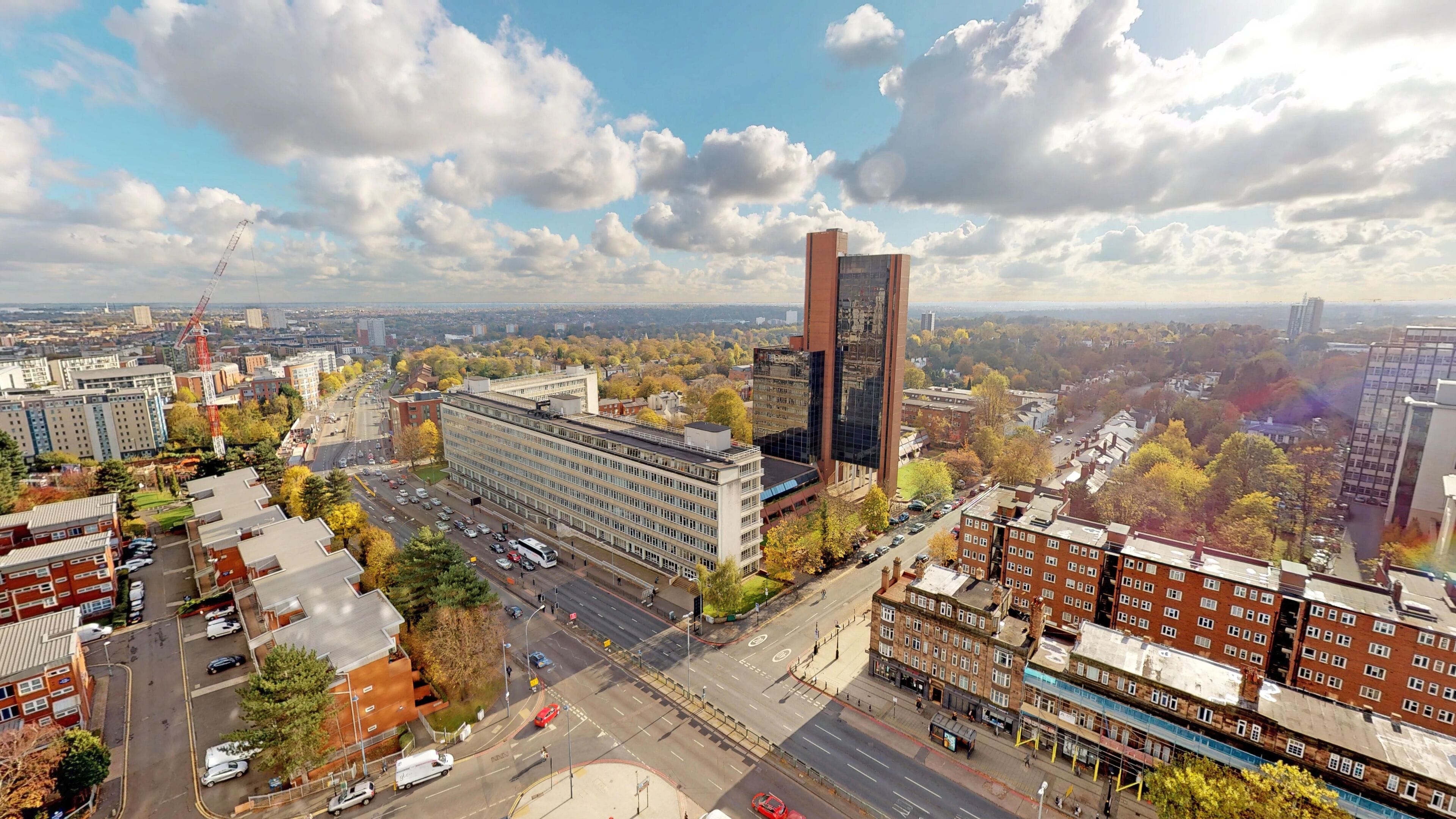 Un paisaje urbano con edificios modernos, una torre roja destacada y una combinación de estructuras residenciales y comerciales.