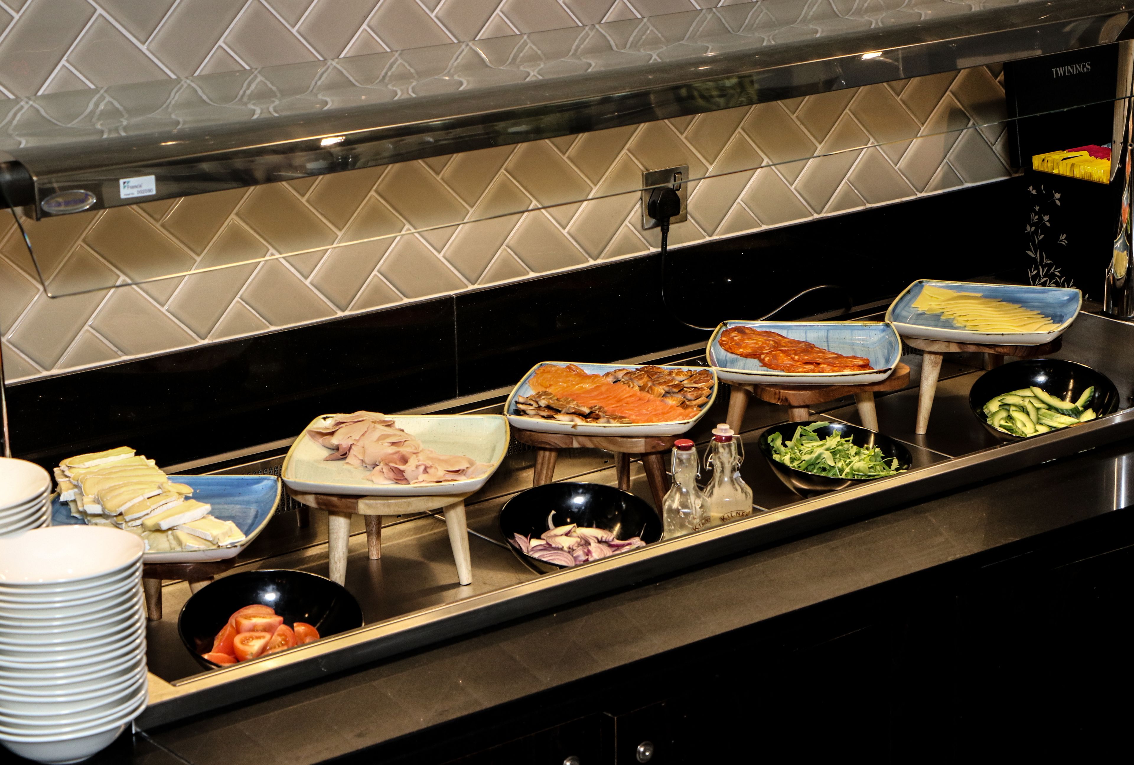 A buffet setup with various food items and condiments.