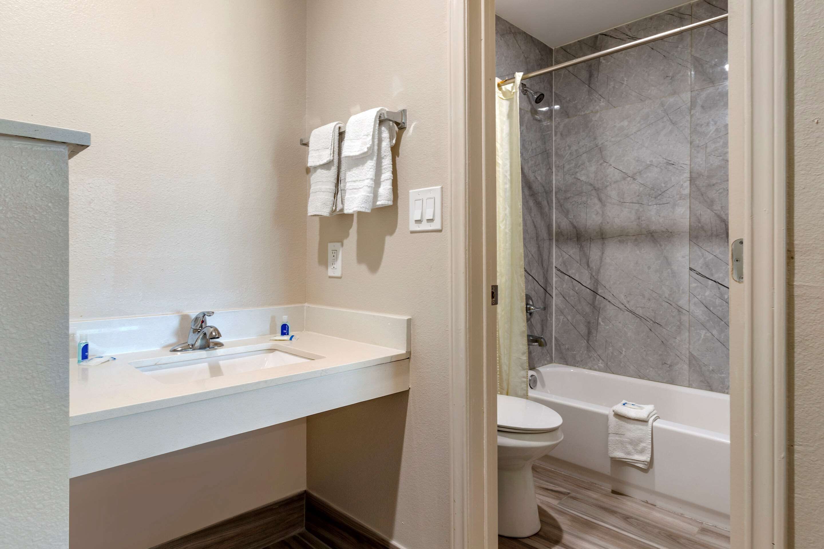 A modern bathroom with a white sink, a toilet, and a bathtub.