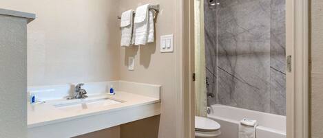 A modern bathroom with a white sink, a toilet, and a bathtub.