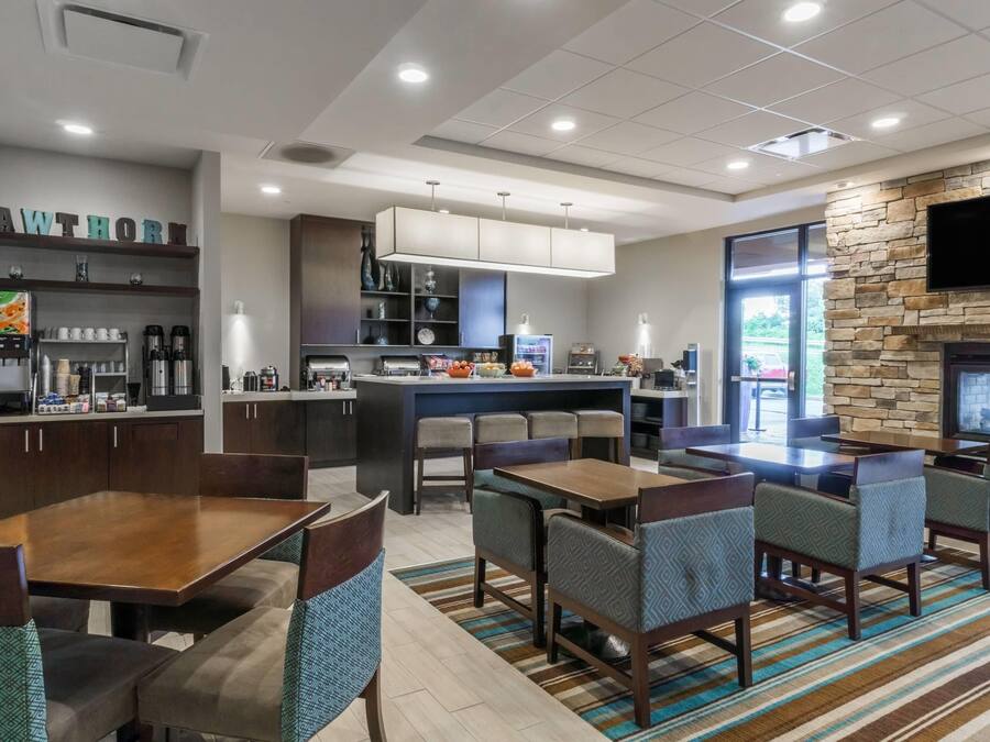 A hotel lobby with a bar area, seating, and a fireplace.