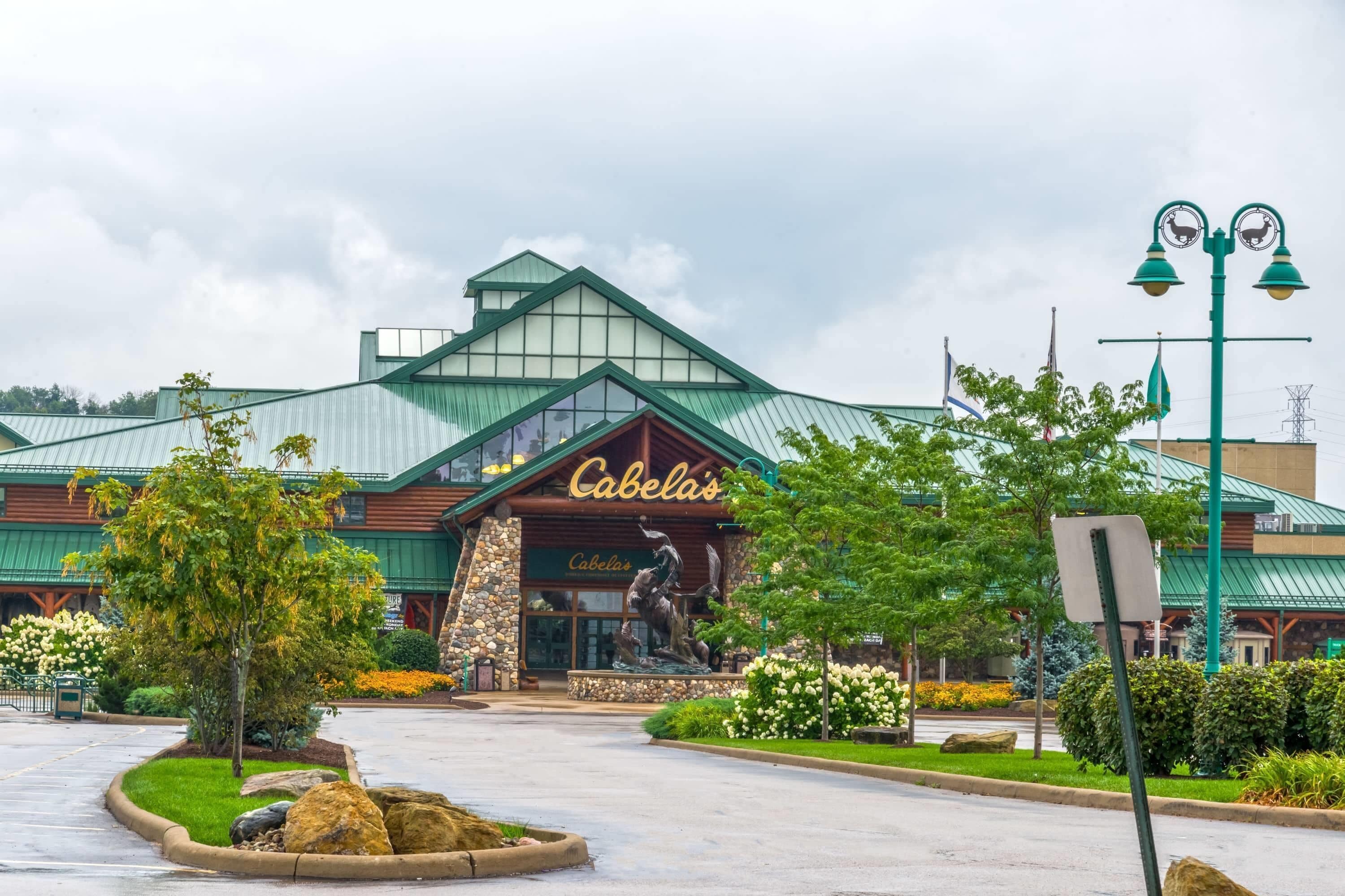 Um edifício com telhado verde e uma placa que diz 'Cabela's'.