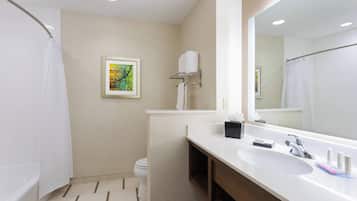 Une salle de bain moderne avec une baignoire, des toilettes, un lavabo et un grand miroir.
