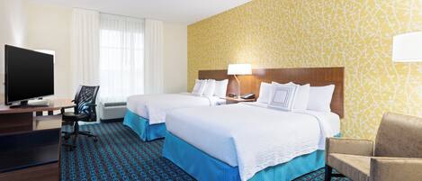 A hotel room with two beds, a desk with a computer, a TV, and a chair.