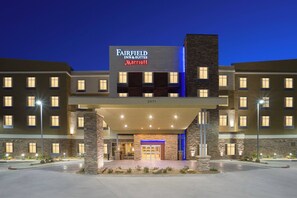 A multi-story Fairfield Inn & Suites Marriott hotel with a prominent entrance, stone facade, and illuminated signage. - Fairfield Inn & Suites Fort Stockton (Fort Stockton)
