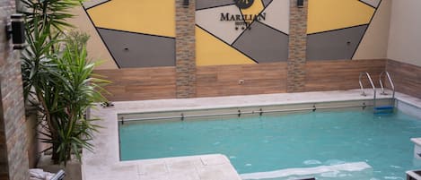 Una piscina al aire libre, sillones reclinables de piscina