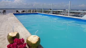 Una piscina al aire libre, sillones reclinables de piscina