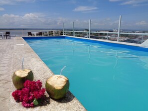 A swimming pool with a clear view of the sea and distant mountains. - Hotel Crucero (Cojimies)