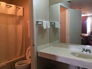 Ein Badezimmer mit einem weißen Waschbecken, einem Spiegel und einer Toilette.
