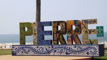 A colorful sign with the name 'PERRE' in large letters, set against a beach backdrop.