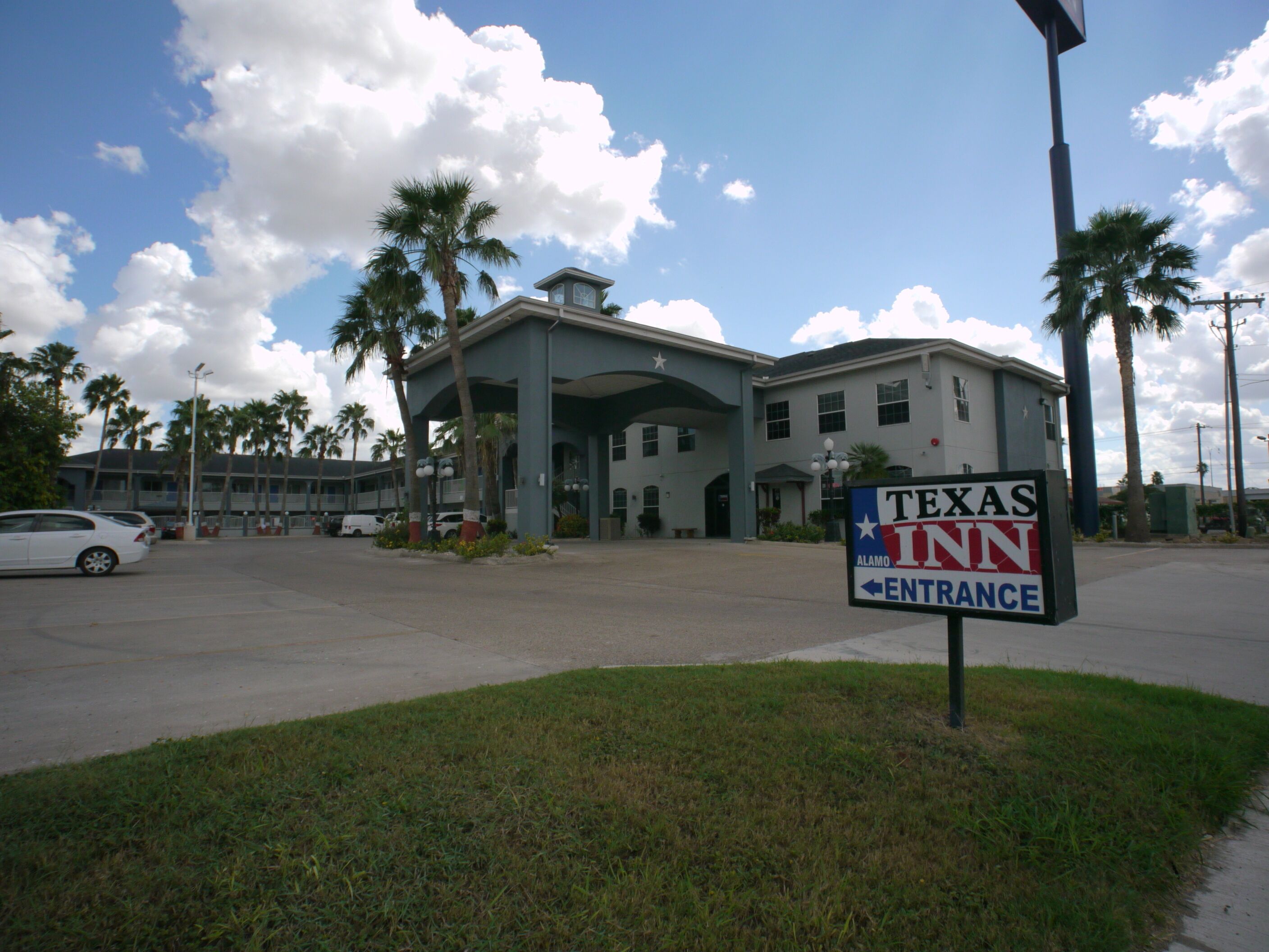 A Texas Inn building with a sign indicating the entrance.