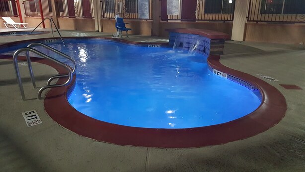An indoor swimming pool with a red border, a ladder, and depth markers. - Texas Inn Alamo (Alamo)