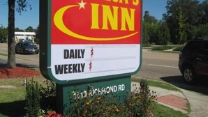 Une enseigne indiquant l’hôtel America’s Inn, avec les tarifs journaliers et hebdomadaires affichés.