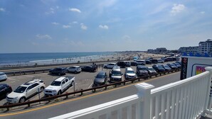 A parking lot with cars and a beach in the background. - Breakers by the Sea (Hampton)