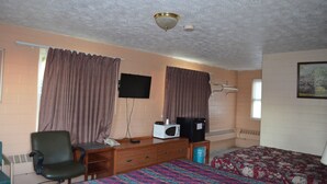 A room with a bed, a desk with a chair, a television, and a microwave. - Admiral Motel (Indianapolis)