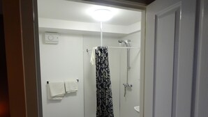 A small, modern bathroom with a shower, toilet, and sink.
