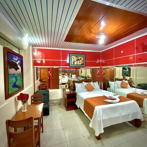 A hotel room with two beds, a dining area, and a bathroom. - Hotel Ventura Isabel (Iquitos)